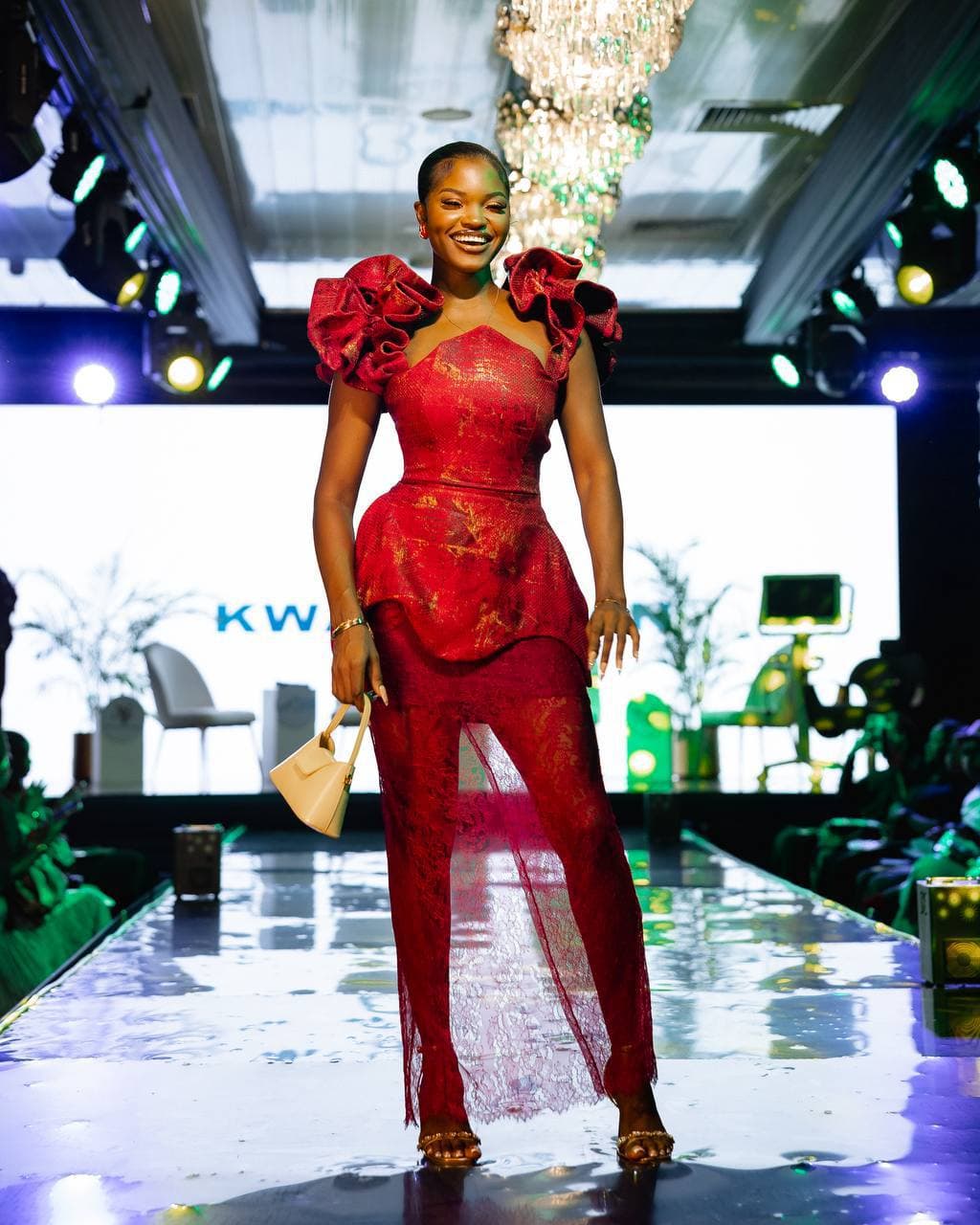 Model walking the runway in a sculptural red dress